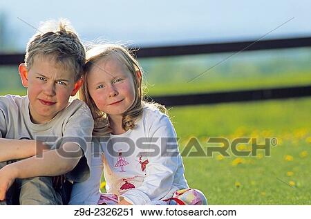 Stock Image - Brother and sister portrait in garden.. Fotosearch