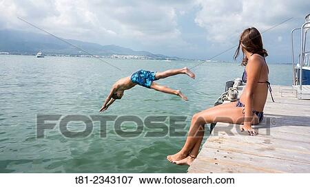 by jumping boy and girl watching sea, San Carlos de la Rapita, Tarragona View Large Photo Image Stock Photo - by jumping boy and girl watching sea, San Carlos de la Rapita, Tarragona. Fotosearch