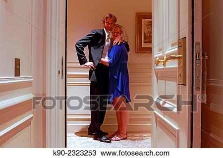 Stock Image - Caucasian man and woman holding each other in front of the door of a hotel room, Hotel Hermitage, Monte Carlo, Monaco, Europe.. Fotosearch