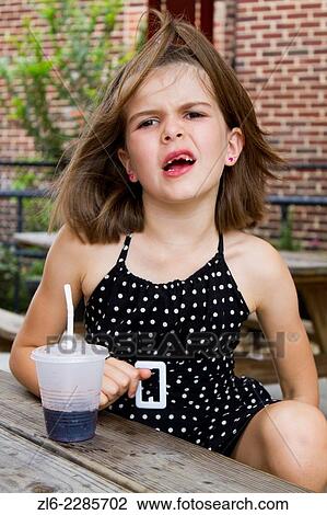 Caucasian young 8 years old, making a face. She has no front teeth and wear a polka dotted black and white dress. She is sitting at a wood table and sipping a coke in a plastic cup with a straw. The background is red bricks. View Large Photo Image Stock Image - Caucasian young 8 years old, making a face. She has no front teeth and wear a polka dotted black and white dress. She is sitting at a wood table and sipping a coke in a plastic cup with a straw. The background is red bricks.. Fotosearch