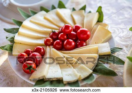 Stock Photograph - Cheese platter with cherry red tomatoes.. Fotosearch