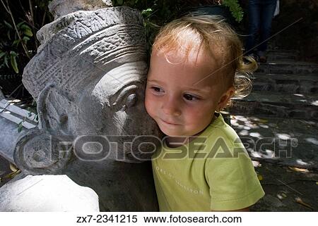 Child posing next to one of the sculptures and statues of Royal Palace. Phnom Penh. Cambodia. Asia. Travel with children's. View Large Photo Image Stock Photography - Child posing next to one of the sculptures and statues of Royal Palace. Phnom Penh. Cambodia. Asia. Travel with children's.. Fotosearch