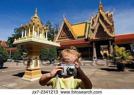 Stock Image - Child walking alone and take pictures in Royal Palace. Phnom Penh.. Fotosearch