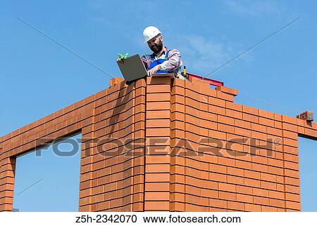 Stock Image - Civil engineer on the construction of a house.. Fotosearch
