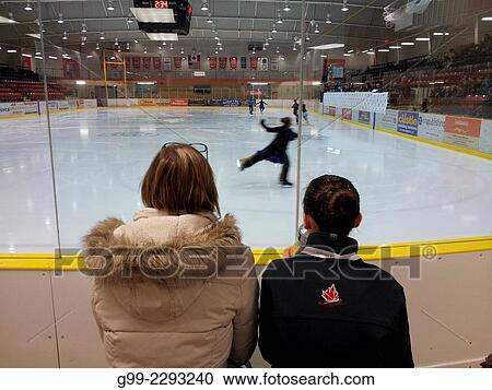 Stock Image - Dance pair warming up as mother and daughter watch at the provincial figure skating finals in Wellington, Ontario, Canada. Fotosearch