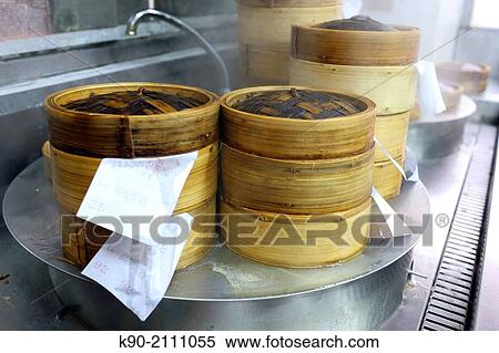 Stock Photography - Dim Sum bamboo baskets simmering in the kitchen, Kowloon, Hong Kong, China, East Asia.. Fotosearch