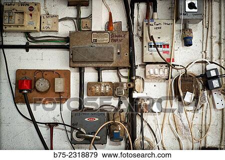 Stock Photo - Electrical panel in a car garage with different switches, plugs, indications and electric cables. In Kettlewell, Skipton, Yorkshire Dales, England, UK, Europe. Fotosearch