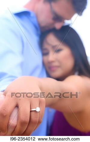 engaged couple embracing, showing off ring View Large Photo Image Stock Image - engaged couple embracing, showing off ring. Fotosearch