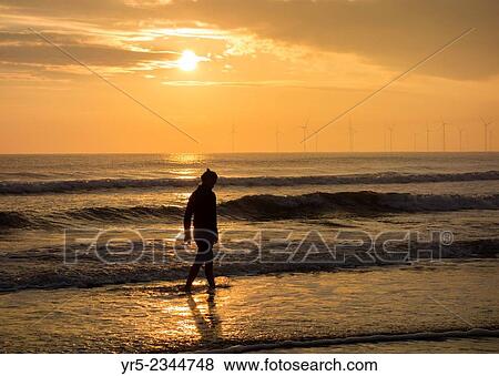 Female jogger cooling down after run in North sea at Seaton Carew, north east England, UK. View Large Photo Image Stock Photo - Female jogger cooling down after run in North sea at Seaton Carew, north east England, UK.. Fotosearch