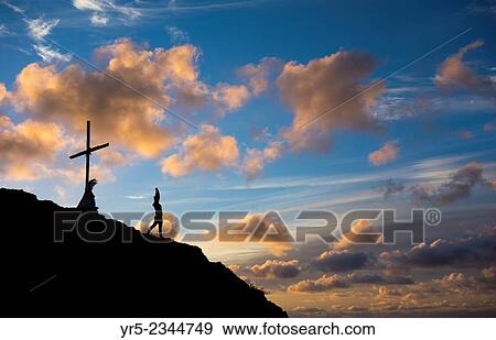 Stock Photo - Female jogger stretching on mountain overlooking Las Palmas city at sunrise. La Isleta, Las Palmas, Gran Canaria, Canary Islands, Spain.. Fotosearch