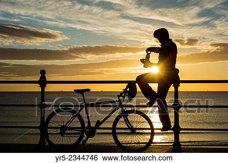 Female mountian biker at sunrise at Seaton Carew on the north east coast of England, United Kingdom. View Large Photo Image Stock Photograph - Female mountian biker at sunrise at Seaton Carew on the north east coast of England, United Kingdom.. Fotosearch