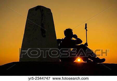 Stock Photo - Hiker on the summit of Roseberry Topping at sunrise. North York Moors, National Park, England, United Kingdom.. Fotosearch