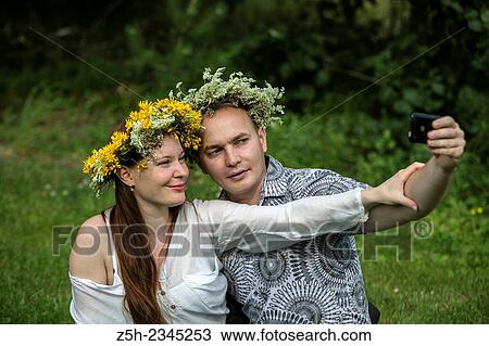 Stock Image - Lovers with wreaths on their heads retired in the park.. Fotosearch