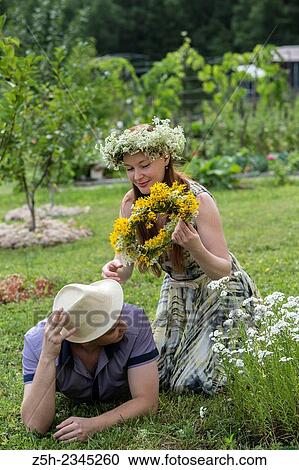 Stock Image - Lovers with wreaths on their heads retired in the park.. Fotosearch