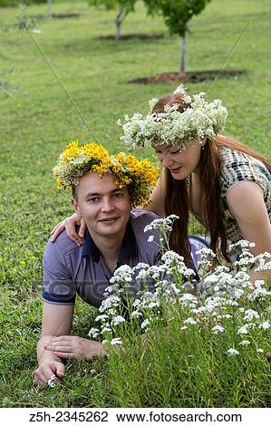 Stock Image - Lovers with wreaths on their heads retired in the park.. Fotosearch