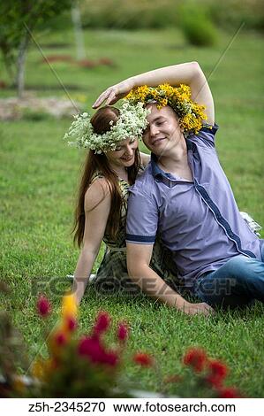 Stock Image - Lovers with wreaths on their heads retired in the park.. Fotosearch