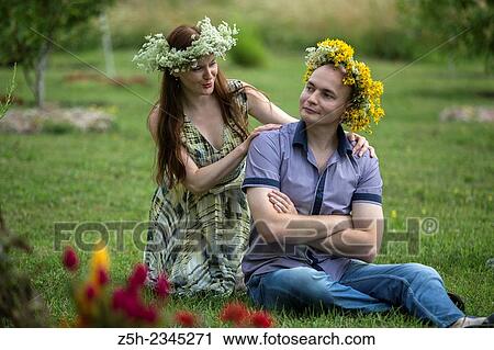 Stock Image - Lovers with wreaths on their heads retired in the park.. Fotosearch