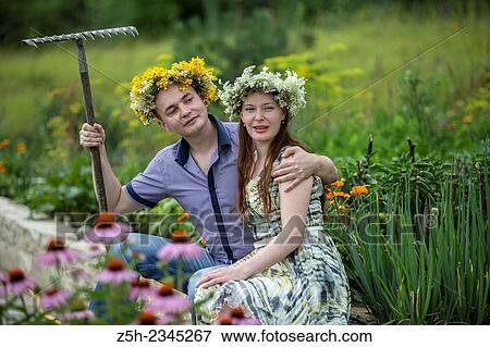 Stock Photo - Lovers with wreaths on their heads retired in the park.. Fotosearch
