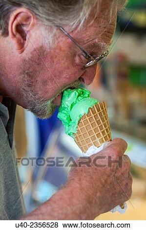 Stock Photo - Man eating ice cream cone.. Fotosearch