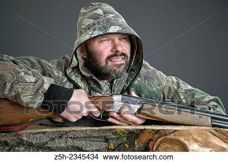 Picture - Man in camouflage with shotgun. Fotosearch
