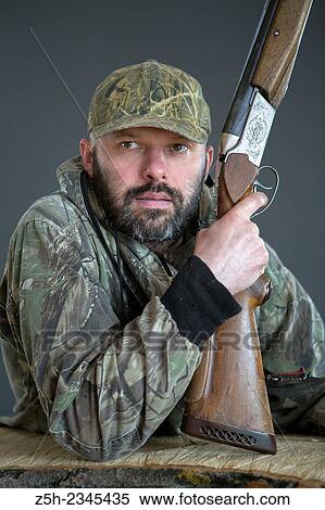 Stock Photography - Man in camouflage with shotgun. Fotosearch