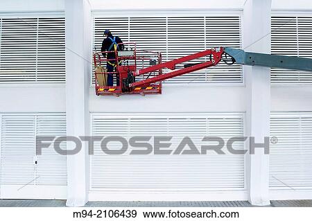 Stock Photo - Man Painting a fence.. Fotosearch