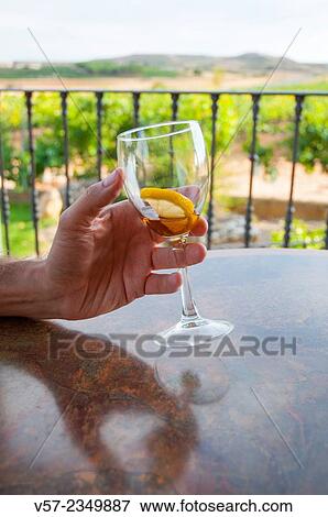 Stock Photo - Man's hand holding an empty glass of liqueur.. Fotosearch