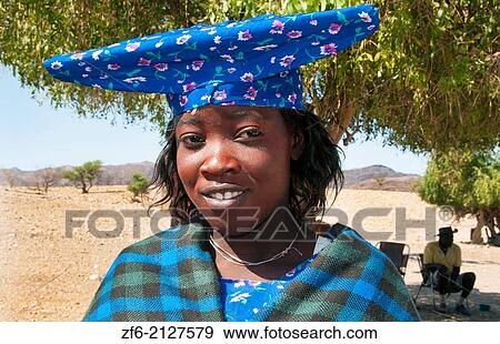 Stock Photo - Namibia Africa Northern Desert colorful Herero tribe woman in plaid dress and hat and traditional costume in Tomakas in Puros Conservancy remote village.. Fotosearch