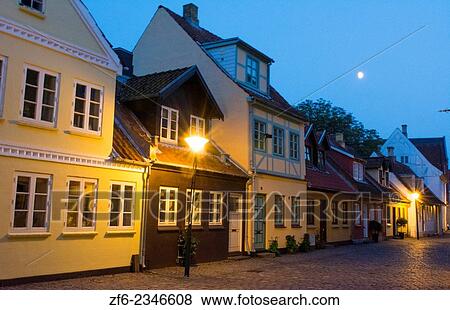 Stock Photo - Odense Denmark beautiful old row homes cobblestone streets at twilight siunset night exposure in Hans Christian Andersen birthplace home.. Fotosearch