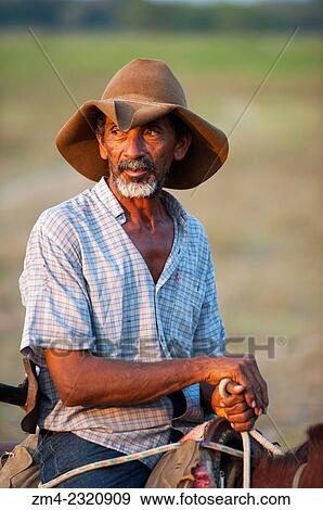 Portrait of a Pantaneiro (local cowboy) on his horse at the Pouso Alegre Lodge in the northern Pantanal in the Mato Grosso province of Brazil. View Large Photo Image Stock Photo - Portrait of a Pantaneiro (local cowboy) on his horse at the Pouso Alegre Lodge in the northern Pantanal in the Mato Grosso province of Brazil.. Fotosearch