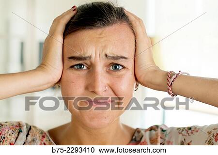 Portrait of young blonde girl with blue eyes and a pierced nose and ear, with the hands holding her head and worried expression View Large Photo Image Stock Image - Portrait of young blonde girl with blue eyes and a pierced nose and ear, with the hands holding her head and worried expression. Fotosearch