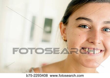 Portrait of young blonde girl with blue eyes and a pierced nose, looking at the camera, cheerful with a calm and relaxed expression. View Large Photo Image Stock Photo - Portrait of young blonde girl with blue eyes and a pierced nose, looking at the camera, cheerful with a calm and relaxed expression.. Fotosearch