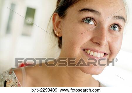Stock Photo - Portrait of young blonde girl with blue eyes and a pierced nose, cheerful with a calm and relaxed expression.. Fotosearch