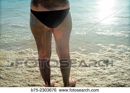 Rear view of an unrecognizable woman in bikini with body smeared mud on the Dead Sea, Israel, Middle East View Large Photo Image Stock Photograph - Rear view of an unrecognizable woman in bikini with body smeared mud on the Dead Sea, Israel, Middle East. Fotosearch