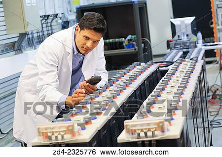 Stock Photograph - Researcher performing a battery test. Classic Solar Batteries. Solar Liquid Cell. Technological research on energy. Energy and Environment. Tecnalia Research and innovation, Bizkaia, Basque Country, Spain. Fotosearch