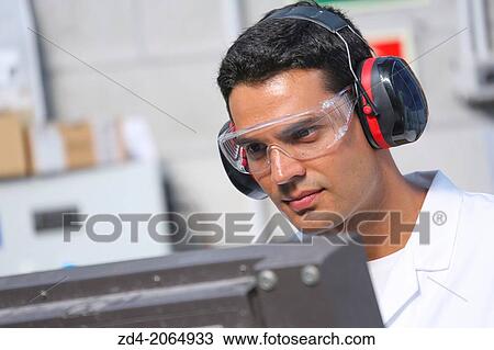 Stock Image - Researcher with glasses and ear protection. Machine for cutting material by water jet and abrasive Industry. Tecnalia Research and innovation. San Sebastian. Donostia. Gipuzkoa. Basque Country. Spain.. Fotosearch
