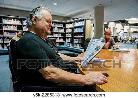Rotterdam, Netherlands. A 70 year oldretired male reading his magazines in the city's public library. View Large Photo Image Stock Image - Rotterdam, Netherlands. A 70 year oldretired male reading his magazines in the city's public library.. Fotosearch