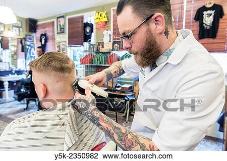 Rotterdam, Netherlands. Barber store Schorem. Barber helping his customer in his barber shop by cutting and modeling his hair. View Large Photo Image Stock Image - Rotterdam, Netherlands. Barber store Schorem. Barber helping his customer in his barber shop by cutting and modeling his hair.. Fotosearch