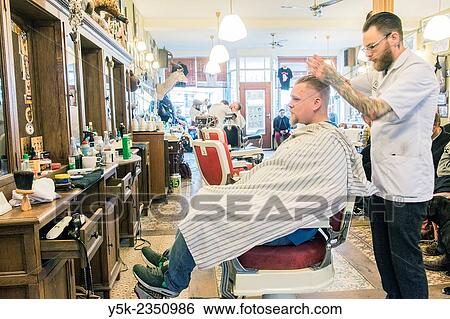Rotterdam, Netherlands. Barber store Schorem. Barber helping his customer in his barber shop by cutting and modeling his hair. View Large Photo Image Stock Photograph - Rotterdam, Netherlands. Barber store Schorem. Barber helping his customer in his barber shop by cutting and modeling his hair.. Fotosearch