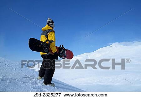 Stock Photo - Snowboarder on ridge, Hudson Bay Mountain, Smithers, BC.. Fotosearch