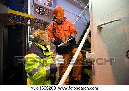 The second officer and the loading master from the dock consult on where to place containers on the deck and in the hold of container-vessel MV Flintercape, before a journey from Rotterdam, Netherlands to Sundsvall, Sweden. View Large Photo Image Stock Image - The second officer and the loading master from the dock consult on where to place containers on the deck and in the hold of container-vessel MV Flintercape, before a journey from Rotterdam, Netherlands to Sundsvall, Sweden.. Fotosearch