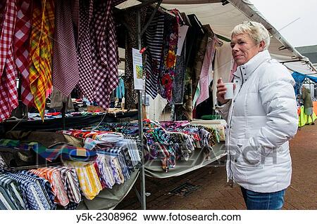 Tilburg, Netherlands. Middle aged market woman with her fabric market stall waiting for customers. View Large Photo Image Stock Image - Tilburg, Netherlands. Middle aged market woman with her fabric market stall waiting for customers.. Fotosearch