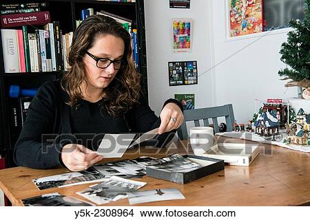 Tilburg, Netherlands. Young, single, and thoughtful woman with her library of books and collection of old black and white photographs. View Large Photo Image Picture - Tilburg, Netherlands. Young, single, and thoughtful woman with her library of books and collection of old black and white photographs.. Fotosearch