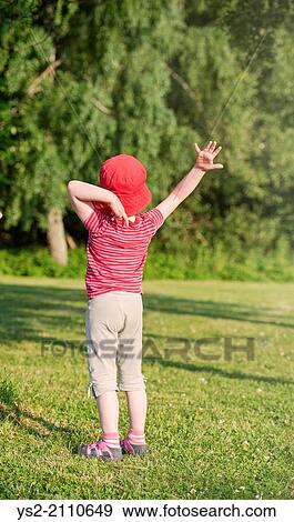 Tranquil summer scene. Young girl in green park making gesture with raised arms. View Large Photo Image Stock Photo - Tranquil summer scene. Young girl in green park making gesture with raised arms.. Fotosearch