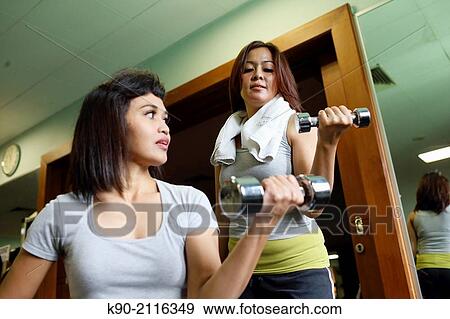 Two asian woman holding a small dumbbell, Jakarta, Indonesia, Southeast Asia. View Large Photo Image Stock Photo - Two asian woman holding a small dumbbell, Jakarta, Indonesia, Southeast Asia.. Fotosearch