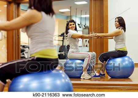 Two asian women doing excercises on a gymnastic ball and seen both in a mirror, Jakarta, Indonesia, Southeast Asia. View Large Photo Image Stock Image - Two asian women doing excercises on a gymnastic ball and seen both in a mirror, Jakarta, Indonesia, Southeast Asia.. Fotosearch