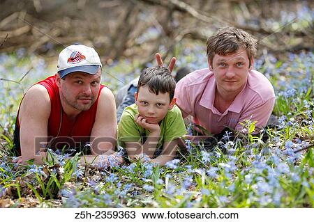 Two men and a boy in the forest on a glade with flowers. View Large Photo Image Stock Image - Two men and a boy in the forest on a glade with flowers.. Fotosearch