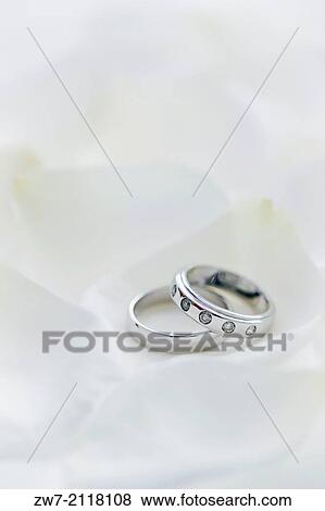 Two wedding rings his and hers set amongst white Rose petals. View Large Photo Image Stock Photo - Two wedding rings his and hers set amongst white Rose petals.. Fotosearch