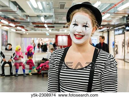 Picture - Utrecht, Netherlands. Painted face of a female mime player in a shopping mall, just before performance.. Fotosearch