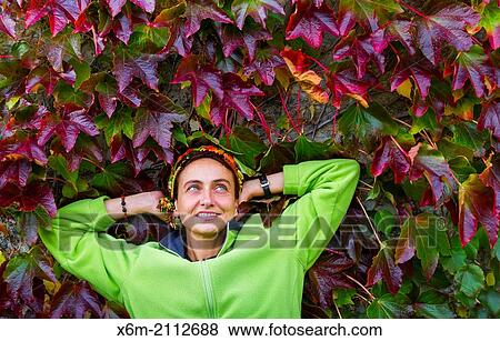 Stock Photo - woman and ivy leaves in autumn.. Fotosearch